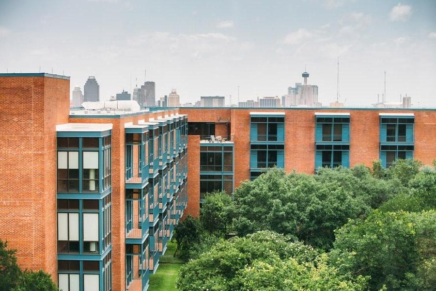 Exterior view of Prassel Hall with San Antonio skyline in the background